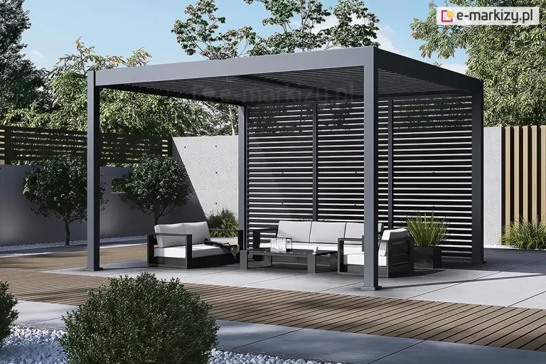 Nowoczesna wolnostojąca pergola ogrodowa Marlo Duo w kolorze antracytowym, której kluczowym elementem są zintegrowane panele boczne w formie poziomych żaluzji. Ta aluminiowa konstrukcja z dachem lamelowym została wyposażona w stałe przesłony boczne z wypełnieniem panelami żaluzjowymi, które harmonizują z grafitowym stelażem, zapewniając skuteczną ochronę przed słońcem, wiatrem oraz zwiększając prywatność użytkowników. Pod zadaszeniem i przed żaluzjową ścianką znajduje się minimalistyczny zestaw mebli tarasowych z jasnymi poduszkami, ustawiony na podłożu z płyt betonowych i drewna. Całość aranżacji dopełnia betonowy murek oraz zadbana roślinność ogrodowa, podkreślająca techniczny i elegancki design paneli bocznych.