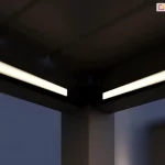 Wykonane nocną porą zdjęcie narożnika pergoli Rubio z czarną konstrukcją i włączonym oświetleniem Led.