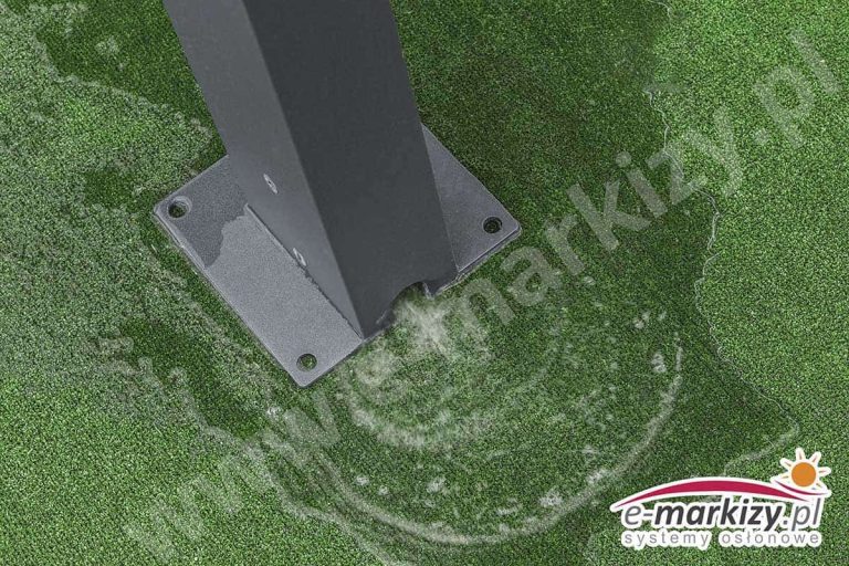 Solidna aluminiowa podpora pergoli Solid w kolorze antracytowym ustawiona na podkładce montażowej na wyłożonym sztuczną prawą podłożu. Podstawa nie została przykręcona do podłoża, ale z otworu przy gruncie wydobywa się woda, która rozlewa się wokoło.