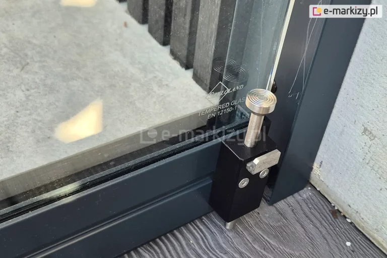 Zbliżenie stopera służącego blokadzie ostatniego skrzydła drzwi szklanych przesuwnych Miros, zabezpieczenie przed otwarciem drzwi.