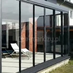 Ściana przesuwna na taras Sotro wykonana z poliwęglanu lub szkła na prowadnicach aluminiowych