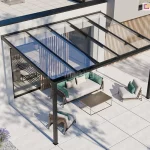 nowoczesne zadaszenie tarasowe model Terano, zamontowane do białej elewacji piętrowego budynku o minimalistycznej architekturze. Konstrukcja wykonana jest z profili aluminiowych w kolorze czarnym lub antracytowym i składa się z dwóch pionowych słupów wspierających oraz ramy dachowej wypełnionej pięcioma taflami przezroczystego szkła. Dach posiada lekki spadek, co umożliwia swobodny odpływ wody opadowej. Pod zadaszeniem zaaranżowano strefę wypoczynkową z nowoczesnymi meblami ogrodowymi: szarą sofą z zielonymi poduszkami, dwoma fotelami w tym samym stylu oraz niskim prostokątnym stolikiem kawowym o ciemnym blacie. Podłoże tarasu wyłożone jest dużymi, jasnymi płytami betonowymi lub ceramicznymi o kwadratowym kształcie. W tle widoczne są duże przeszklenia drzwi tarasowych oraz pionowe lamele dekoracyjne wykonane z jasnego drewna, zamontowane na ścianie budynku. W dolnym lewym rogu kadru widać fragmenty ozdobnej roślinności w postaci kęp lawendy posadzonej w białym żwirze. Całość kompozycji jest oświetlona jasnym, dziennym światłem, rzucającym wyraźne cienie konstrukcji na powierzchnię tarasu.