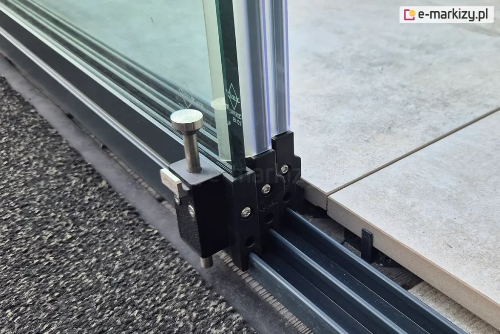 Szklane ściany przesuwne bezramowe Miros zamocowane przy płycie tarasowej składające się z trzech paneli, wykończonych uszczelkami przeciw przeciągowymi gumowymi oraz stoperem zamieszczonym na ostatnim wewnętrznym skrzydle.