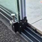 Szklane ściany przesuwne bezramowe Miros zamocowane przy płycie tarasowej składające się z trzech paneli, wykończonych uszczelkami przeciw przeciągowymi gumowymi oraz stoperem zamieszczonym na ostatnim wewnętrznym skrzydle.