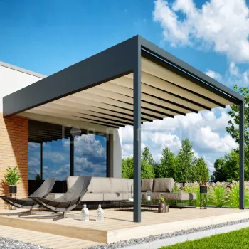 Pergola Luxury montowana do ściany, z tkaninowym dachem przesuwanym w prowadnicach i zintegrowaną rynną boczną odprowadzającą wodę, zadasza nowoczesny taras z leżakami i przestronną sofą ogrodową. Solidna, antracytowa konstrukcja podkreśla luksusowy charakter pergoli, a całość otacza zadbany ogród.