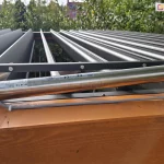 Układ uchylny dachu z panelami w pozycji pionowej wraz z silnikiem zamontowanym na belce poziomej pergoli