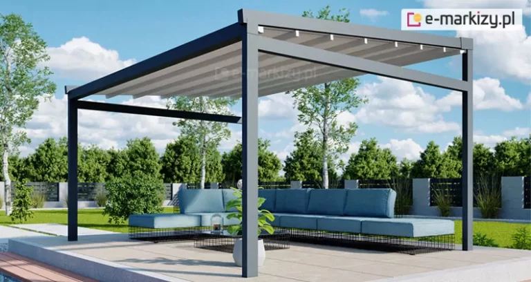 Zdjęcie prezentuje produkt pergola tarasowa wolnostojąca Moderno w nowoczesnej aranżacji ogrodowej przy basenie. Konstrukcja pergoli charakteryzuje się minimalistyczną formą, wykonaną z solidnych profili aluminiowych o kwadratowym przekroju w kolorze głębokiego antracytu. Zadaszenie stanowi jasny, kremowy materiał techniczny rozpięty na ruchomych poprzeczkach, który jest zamontowany pod lekkim skosem, co ułatwia odprowadzanie wody opadowej. Pod pergolą znajduje się strefa wypoczynkowa z dużym, narożnym meblem modułowym w kolorze jasnobłękitnym, ustawionym na podłożu z jasnych, wielkoformatowych płyt tarasowych. Obok sofy stoi niski, nowoczesny stolik kawowy z szklanym blatem, na którym umieszczono dekoracyjne naczynia. Tło kompozycji stanowi zadbany ogród z zielonym trawnikiem, niską roślinnością ozdobną oraz nowoczesnym ogrodzeniem panelowym w kolorze czarnym z betonowymi słupkami. Po prawej stronie kadru widoczna jest krawędź błękitnej tafli wody basenowej, a w oddali gęsta ściana drzew liściastych pod jasnym, lekko zachmurzonym niebem. Cała scena jest oświetlona naturalnym, dziennym światłem, podkreślającym detale wykończenia pergoli oraz fakturę materiałów.