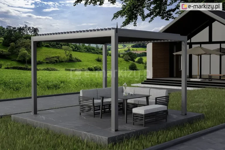 Wizualizacja nowoczesnej, wolnostojącej pergoli SB350 Selt w kolorze antracytowym, umieszczonej na ciemnoszarym tarasie z płyt kamiennych. Pod zadaszeniem znajduje się komplet mebli ogrodowych: jasnoszary narożnik, stół obiadowy oraz dopasowana pufa. Dach pergoli wyposażony jest w ruchome lamele, które są lekko uchylone. Konstrukcja z czterema słupami nośnymi jest wkomponowana w otwartą przestrzeń z widokiem na zielone pagórki, łąki i drzewa pod błękitnym niebem. W tle widoczny jest fragment nowoczesnego domu o ciemnej elewacji z dużymi przeszkleniami oraz beżowy parasol ogrodowy.