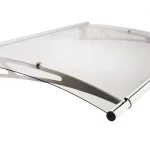 Zdjęcie przedstawia nowoczesne zadaszenie drzwiowe o lekko łukowatym kształcie, wykonane z materiałów o wysokim połysku. Głównym elementem konstrukcyjnym jest przezroczysta płyta akrylowa o gładkiej powierzchni, która pozwala na swobodny przepływ światła dziennego. Płyta zamocowana jest na dwóch metalowych wspornikach bocznych wykonanych ze stali nierdzewnej, które charakteryzują się ażurowym wzorem z podłużnymi wycięciami. System mocowania tafli do wsporników wykorzystuje punktowe, okrągłe uchwyty umieszczone w górnej części ramion. Na przedniej krawędzi daszka znajduje się aluminiowa rynienka odpływowa o cylindrycznym kształcie, która wystaje poza obrys boczny konstrukcji i jest zakończona ciemnymi zaślepkami. Tylna krawędź, przeznaczona do montażu przyściennego, została wykończona cienką listwą maskującą z widocznymi otworami montażowymi. Całość prezentuje minimalistyczny i techniczny design, podkreślony przez srebrzyste wykończenie elementów metalowych.