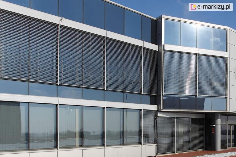 Żaluzje zewnętrzne fasadowe z kasetą oval z czujnikiem pogodowym, który automatycznie zarządza ruchem osłon zamocowanych na przeszklonej fasadzie dużego biurowca