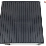 Widok z góry na dach bioklimatycznej pergoli tarasowej w kolorze antracytowym. Konstrukcja przedstawiona jest na czystym, białym tle, ukazując precyzyjny układ szczelnie zamkniętych lamel aluminiowych. Płaska powierzchnia dachu składa się z licznych, równoległych paneli o matowym wykończeniu, które tworzą jednolitą i nieprzepuszczalną osłonę. W dolnej części kadru widoczne są jedynie górne fragmenty czterech pionowych słupów nośnych oraz krawędź ramy konstrukcyjnej. Perspektywa z lotu ptaka podkreśla minimalistyczny, geometryczny design zadaszenia oraz wysoką jakość spasowania elementów mechanizmu ruchomego dachu.