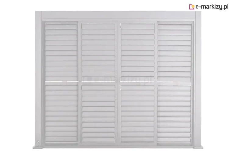 Biała pergola aluminiowa Gloria prezentowana na jednolitym jasnym tle w rzucie od frontu ukazująca system bocznych przesłon żaluzjowych. Konstrukcja składa się z masywnej ramy nośnej o geometrycznych kształtach, wewnątrz której zamontowano cztery pionowe panele typu shutter. Każdy panel podzielony jest poprzeczką na dwie sekcje, wypełnione ruchomymi, poziomymi lamelami, które są obecnie ustawione w pozycji zamkniętej lub lekko nachylonej, tworząc szczelną barierę wizualną. Powierzchnia aluminium jest gładka i wykończona matowym lakierem w kolorze czystej bieli. Po lewej stronie u dołu widoczny jest detal stopy montażowej słupa nośnego przytwierdzonej do płaskiej podstawy. Górna belka ramy jest szeroka i stabilna, domykając optycznie całą konstrukcję i maskując mechanizmy sterujące przesłonami. Całość systemu charakteryzuje się wysoką precyzją spasowania elementów modułowych, co podkreśla nowoczesny i techniczny charakter zabudowy tarasowej.