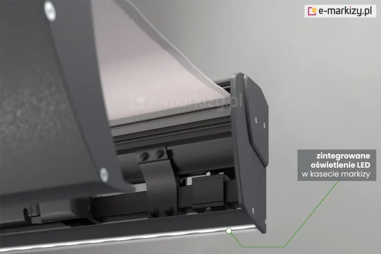 Markiza Corsica w pełnej kasecie w kolorze srebrzysty grafit, widoczna częściowo od strony prawego boku. Wewnątrz kasety widoczne jej mocowanie do belki kwadratowej, mocowanie uchwytu ściennego oraz częściowo przesłonięte przez belkę przednią mocowanie ramienia. Z kasety wysunięte jest także białe poszycie. W dolnej części kasety, wzdłuż ściany widoczne oświetlenie ledowe w postaci paska o jasnej, neutralnej barwie. Całość ukazana na jasnoszarym tle. Na pasku ledowym w pobliżu boczka markizy umieszczono biały okrągły znacznik z zieloną ramką, od którego zielona linia prowadzi do umieszczonego na prostokątnym ciemnoszarym polu napis "zintegrowane oświetlenie LED w kasecie markizy".