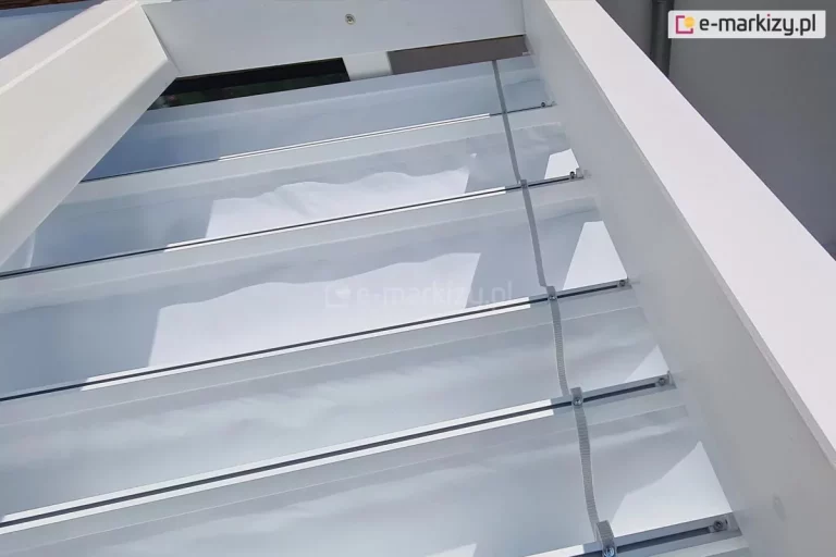 Zbliżenie szczegółów dachu rzymskiego Supro na pergoli drewnianej Moza, widoczna tasiemka do sterowania dachem łącząca belki przeciwwietrzne osłony.