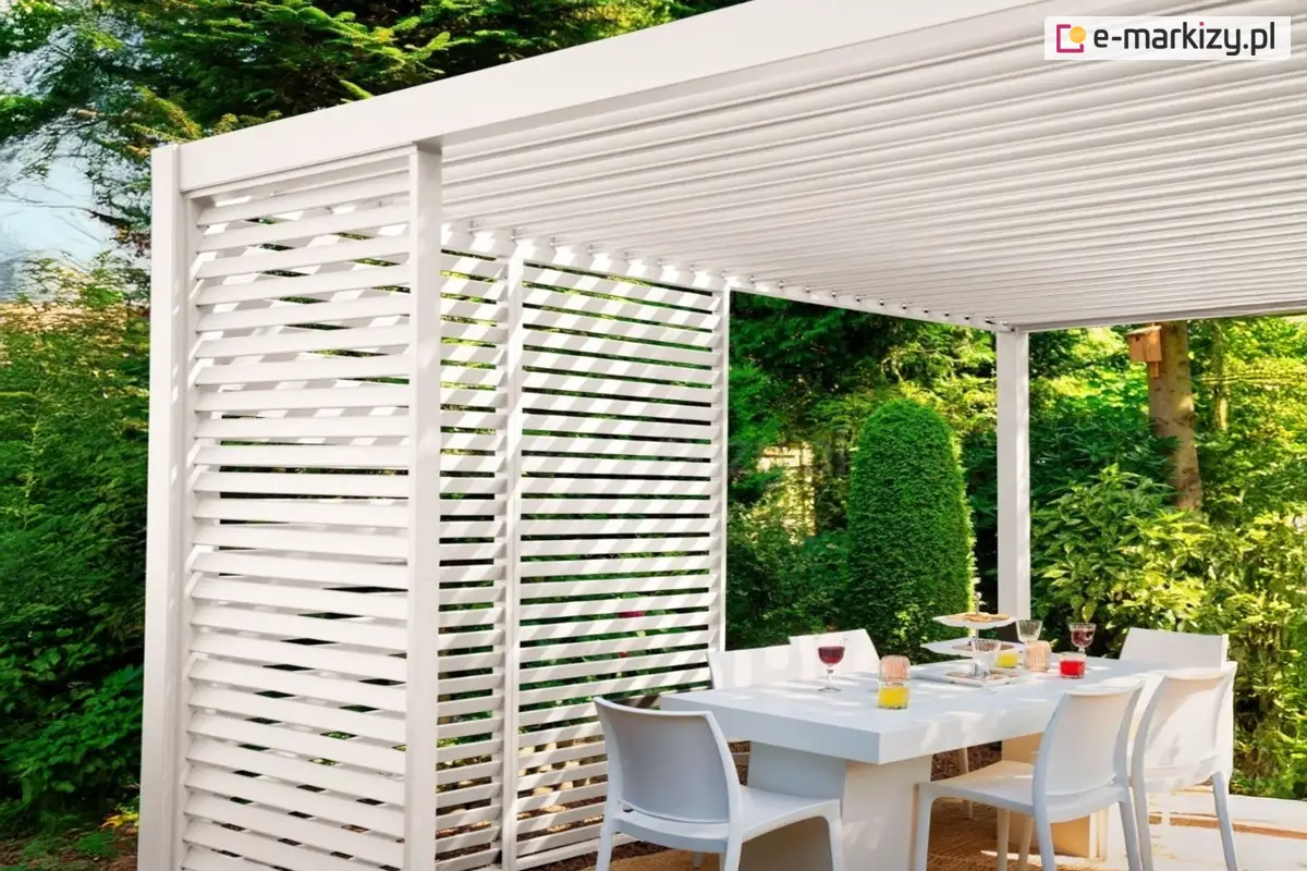 Biała pergola Gloria z aluminiowymi panelami żaluzjowymi zamontowanymi w narożniku. Estetyczne wykończenie konstrukcji tarasowej zapewniające ochronę i elegancję.