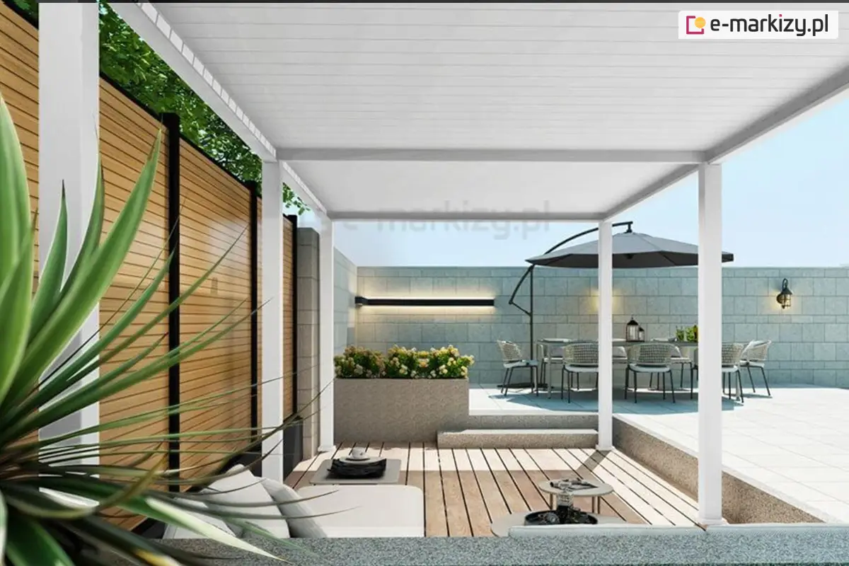 Elegancka, biała pergola ogrodowa Marlo z poziomymi lamelami dachowymi tworzy przytulną przestrzeń wypoczynkową. W tle widoczna jest część jadalniana z dużym stołem, krzesłami i parasolem, a całość dopełniają betonowe ściany ogrodzenia, dekoracyjne oświetlenie oraz nowoczesna donica z kwiatami.