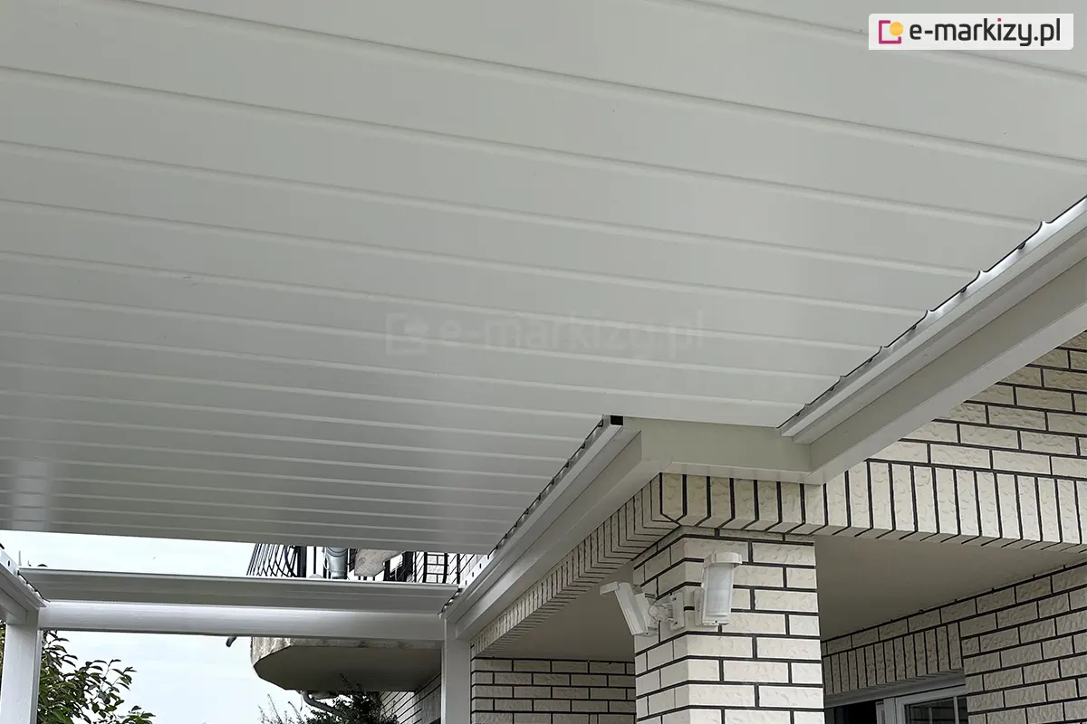 Ruchome zadaszenie lamelowe SB400 R firmy Selt z białymi prowadnicami i lamelami przyciętymi tak, aby pasowały do tarasu w kształcie litery L