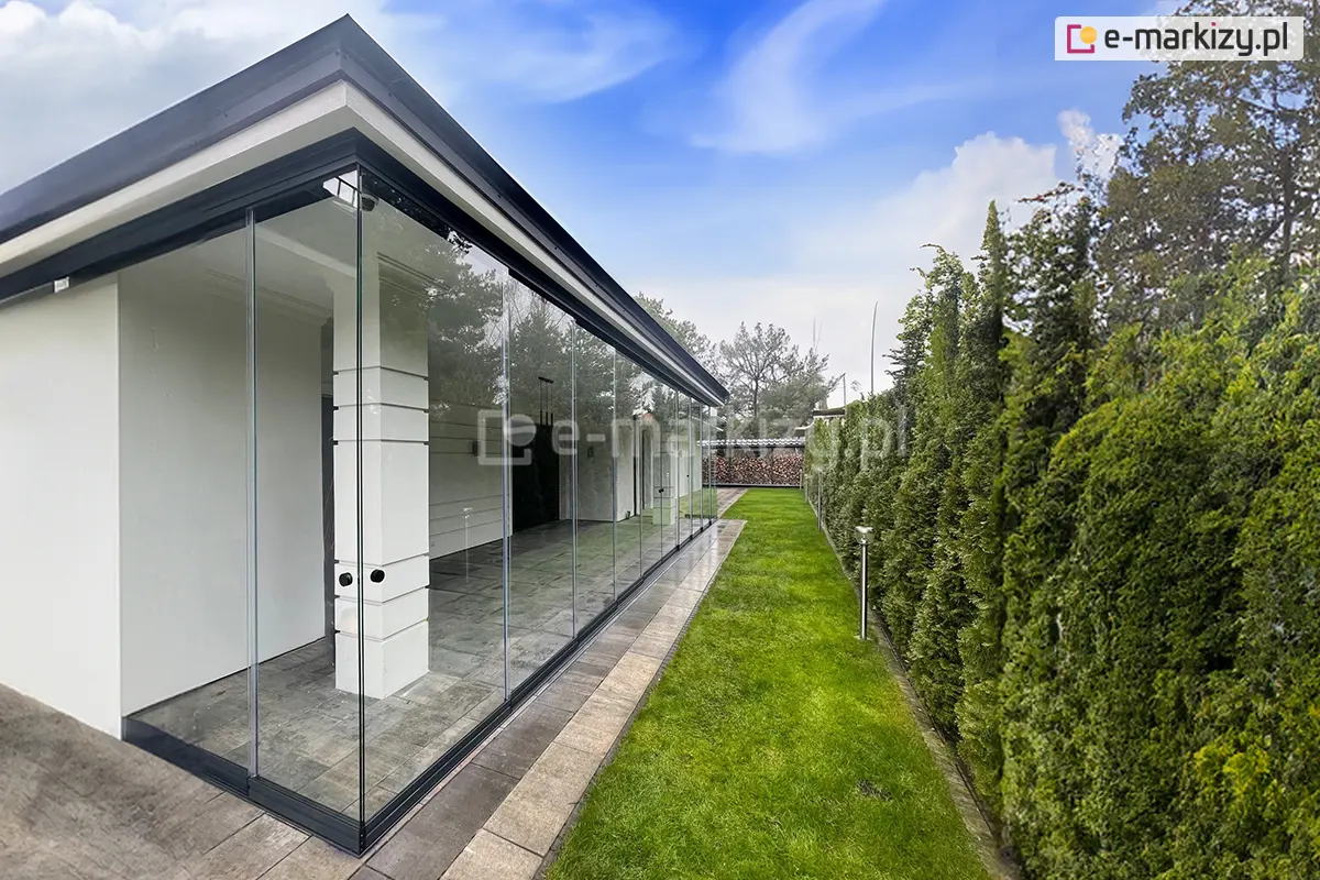 Duża ściana szklana wykonana z wielkoformatowych drzwi przesuwnych Miros, tworząca szczelną zabudowę schludnego tarasu w stylu nowoczesnym