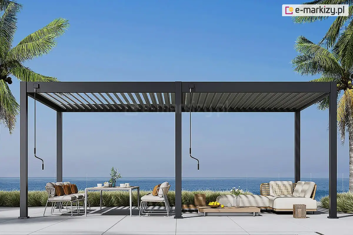 Pergola Marlo z nowoczesnym zadaszeniem lamelowym w odcieniu antracytowym, ustawiona nad strefą relaksu z widokiem na morze. Konstrukcja wolnostojąca na jasnym tarasie. W tle roślinność nadmorska i palmy, podkreślające wakacyjny klimat oraz elegancki charakter aranżacji. Idealna pergola na taras lub ogród z widokiem.