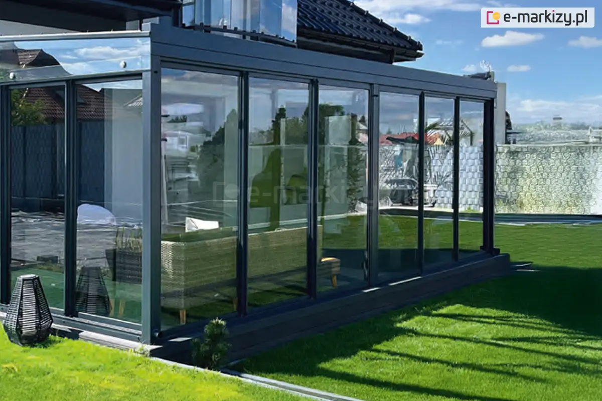 Nowoczesna szklana zabudowa tarasu z dwoma systememami 3-skrzydłowych ramowych drzwi przesuwnych Sotro w ciemnej konstrukcji aluminiowej
