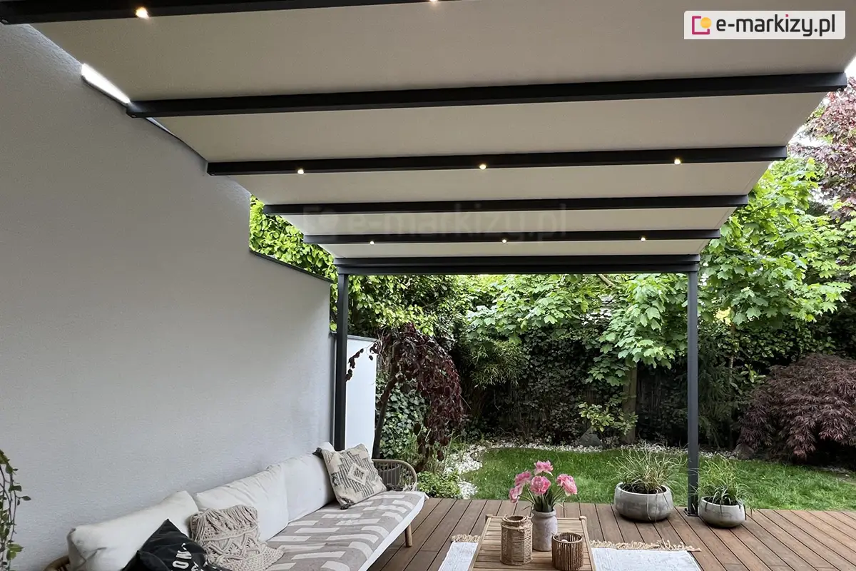 Nowoczesna pergola tarasowa Aura z rozsuwaną tkaniną w jasnym kolorze i zintegrowanym oświetleniem LED, tworząca eleganckie zadaszenie nad letnią strefą wypoczynku dla całej rodziny