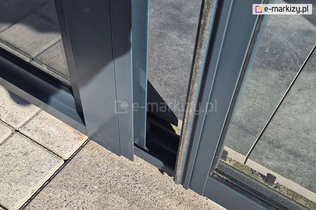 Skrajny panel przesuwny Sotro z uszczelką szczotkową, wsuwający się w zamontowany do konstrukcji pergoli panel boczny.