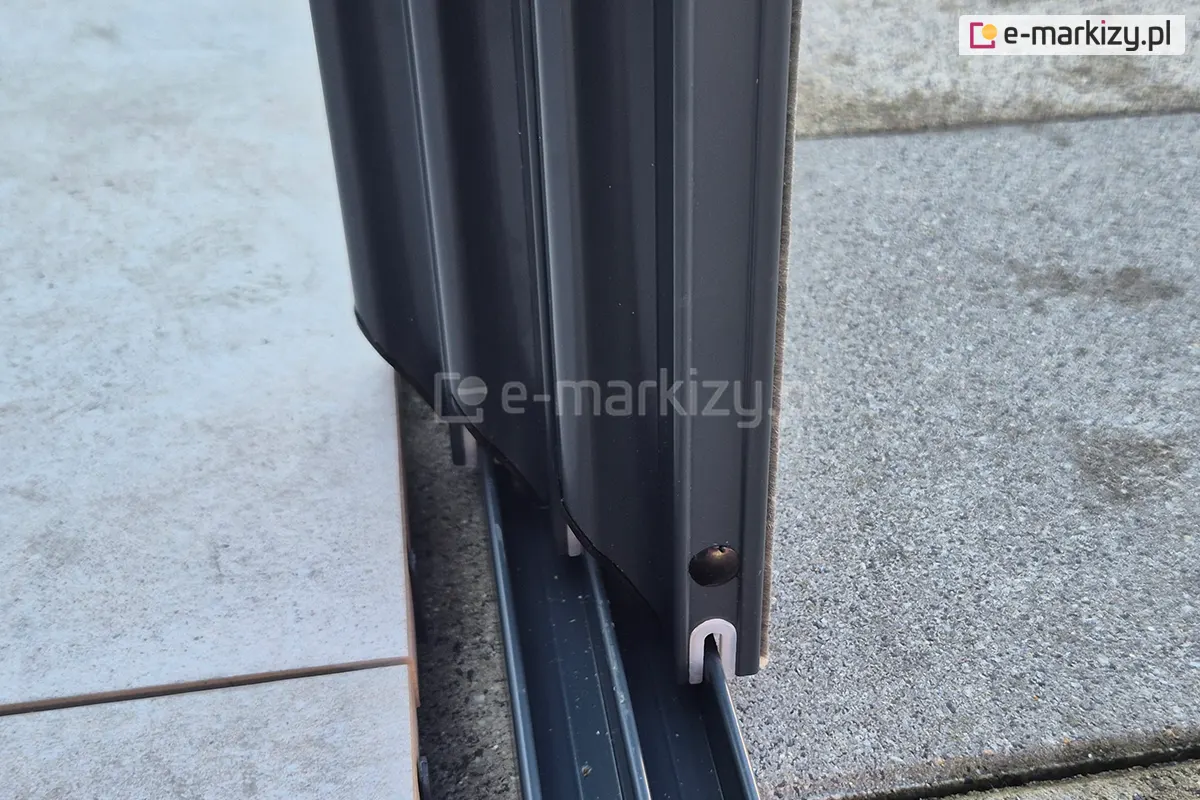 Detal systemu drzwi przesuwnych Sotro, prezentujący masywne panele szklane w antracytowej ramie z aluminium, które dzięki zastosowanej prowadnicy otwierają się lekko i płynnie.