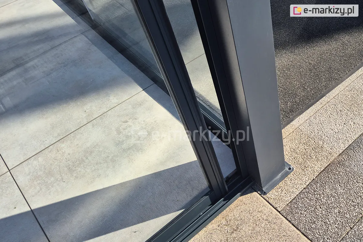 Dolna część systemu drzwi szklanych Sotro, zamontowanego do aluminiowej konstrukcji pergoli.