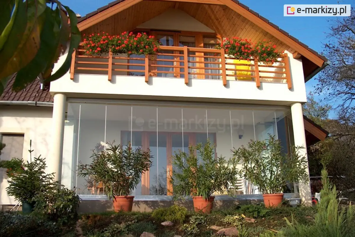 Przeszklona zabudowa tarasu z systemem bezramowym Miros – eleganckie rozwiązanie do osłony dużej przestrzeni wypoczynkowej w domu jednorodzinnym.